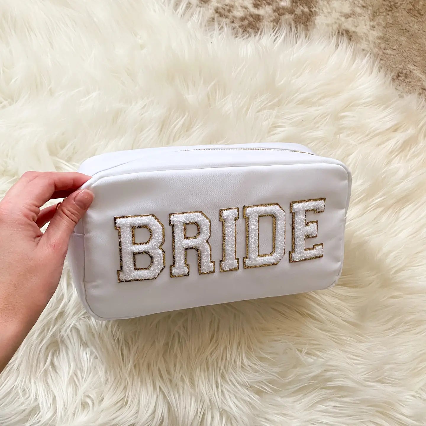 White BRIDE bag held in hand, showing size and texture for the large bag.