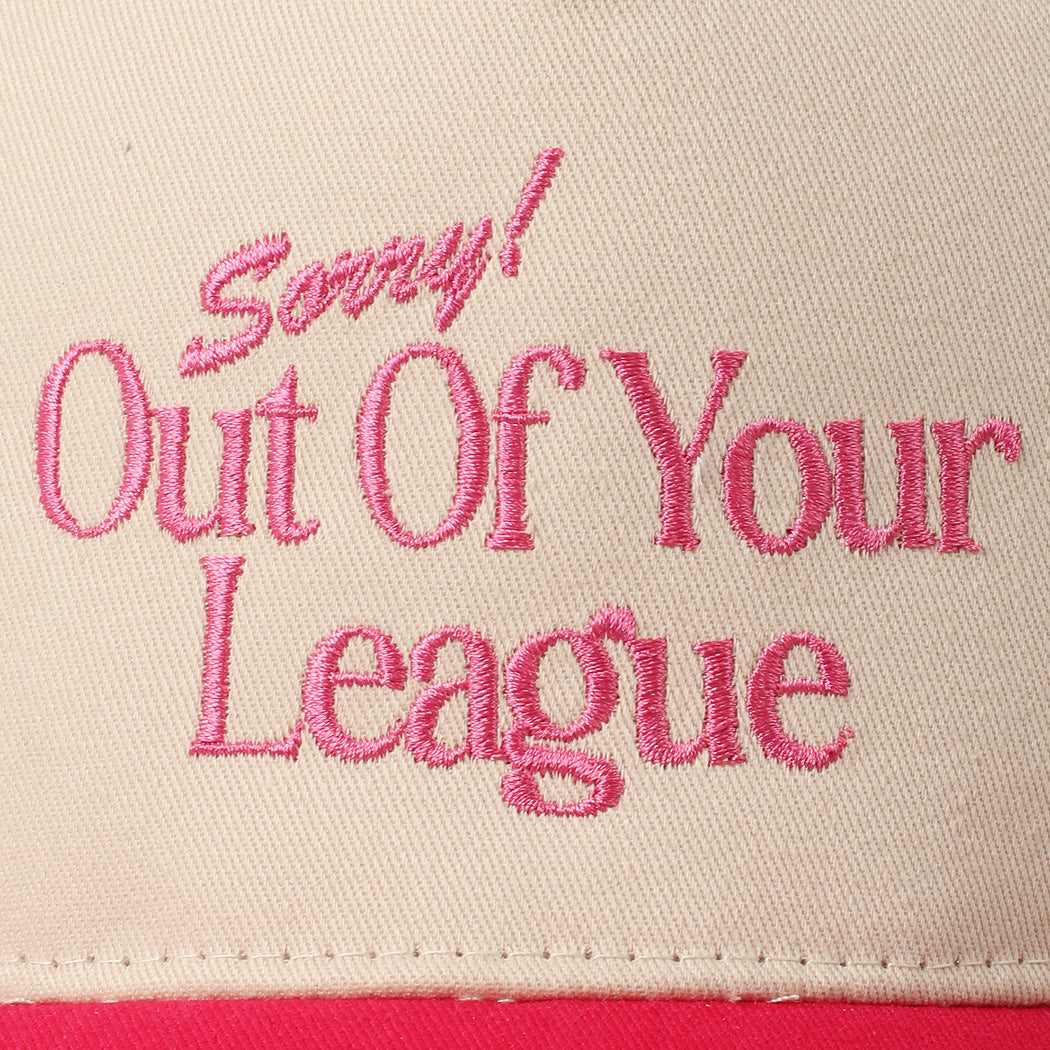 Close-up of pink embroidery reading Sorry! Out Of Your League on beige cotton cap
