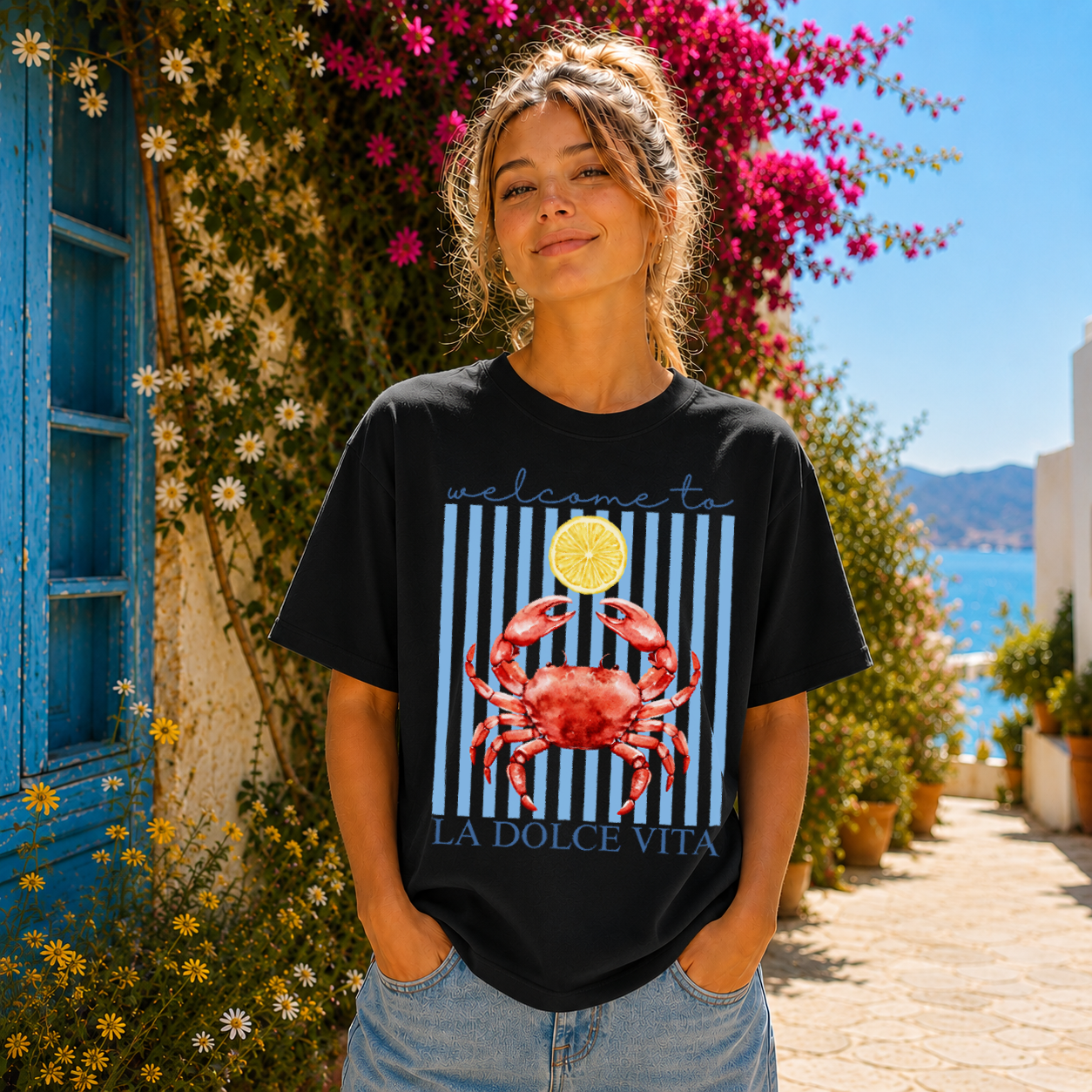 Woman wearing a black t-shirt with a red crab design in a scenic outdoor setting.