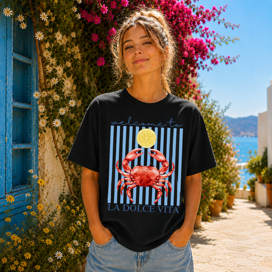 Woman wearing a black t-shirt with a red crab design in a scenic outdoor setting.