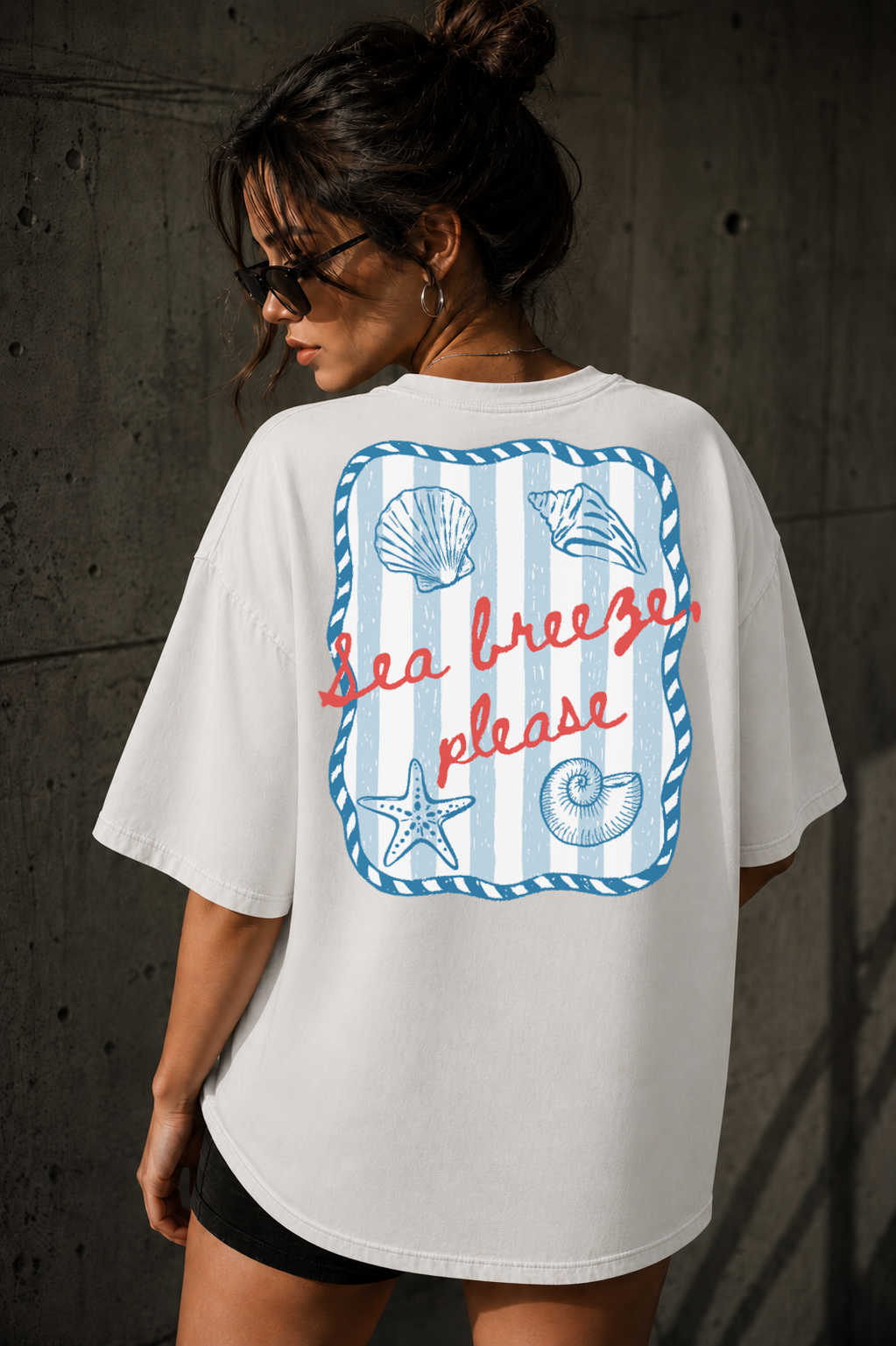 Woman wearing a white t-shirt with a beach-themed design and text.