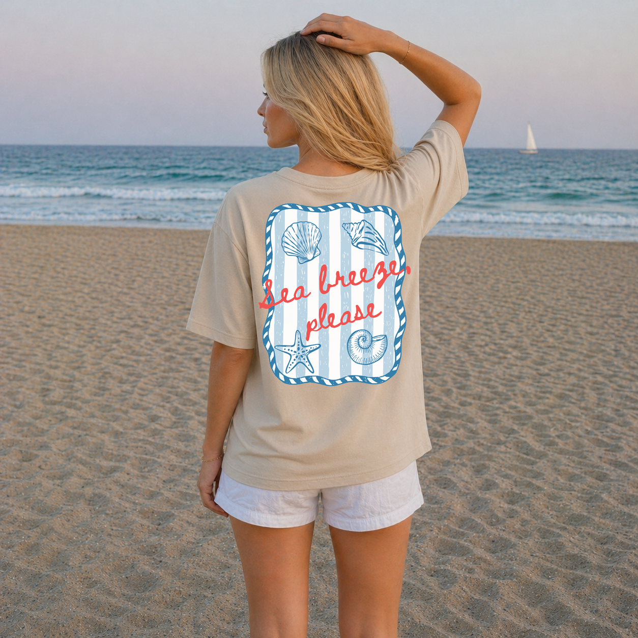 Woman on a beach wearing a t-shirt with a 'Sea Breeze Please' design.