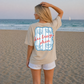 Woman on a beach wearing a t-shirt with a 'Sea Breeze Please' design.