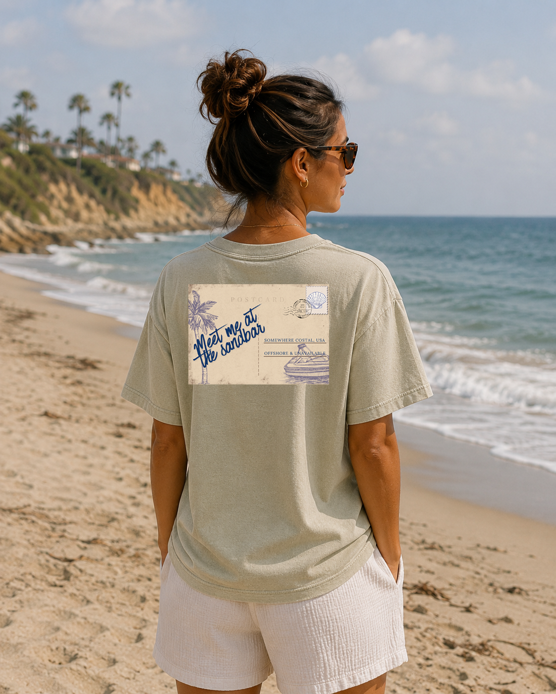 Woman on a beach wearing a t-shirt with a graphic design.